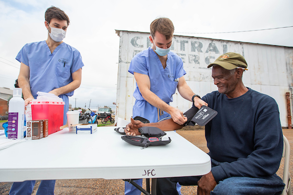 Medical students administer blood pressure screenings with the Jackson Free Clinic.